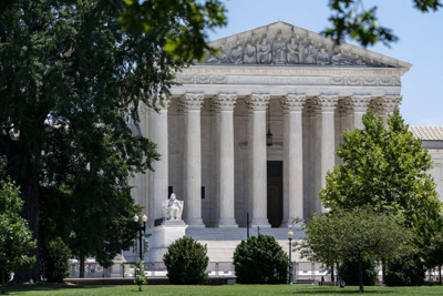 Supreme Court of the United States building seen through trees on the U.S. Capitol grounds